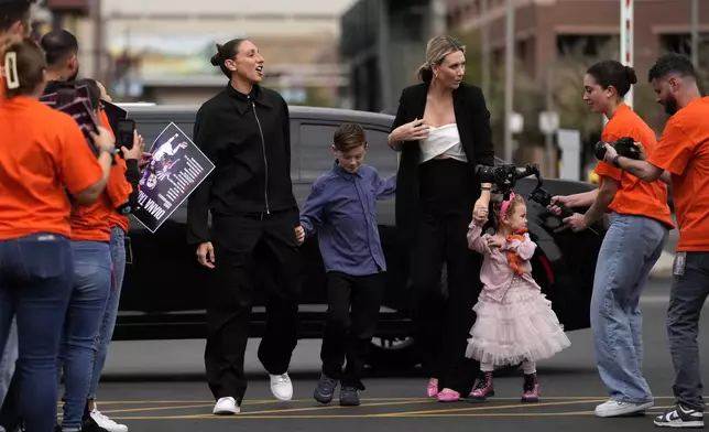 Former Phoenix Mercury player Diana Taurasi, left, arrives for her retirement news conference with wife, Penny Taylor, and their children Leo Michael, and Isla, right, Thursday, March 13, 2025, in Phoenix. (AP Photo/Matt York)