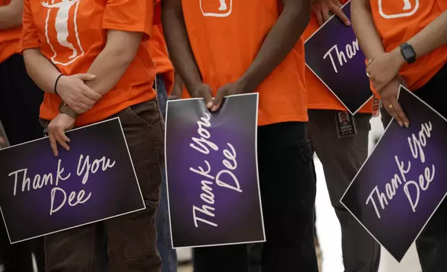 Phoenix Mercury employees hold thank you signs for Diana Taurasi as she speaks during her retirement news conference, Thursday, March 13, 2025, in Phoenix. (AP Photo/Matt York)