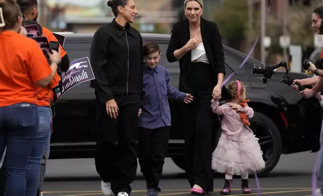 Former Phoenix Mercury player Diana Taurasi, left, arrives for her retirement news conference with wife, Penny Taylor, and their children Leo Michael, and Isla, right, Thursday, March 13, 2025, in Phoenix. (AP Photo/Matt York)