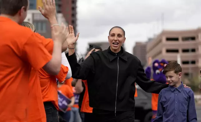 Former Phoenix Mercury player Diana Taurasi arrives for her retirement news conference with son Leo Michael, Thursday, March 13, 2025, in Phoenix. (AP Photo/Matt York)