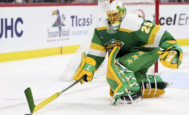Minnesota Wild goaltender Marc-Andre Fleury (29) lunges for the puck during the second period of an NHL hockey game against the Pittsburgh Penguins, Sunday, March 9, 2025, in St. Paul, Minn. (AP Photo/Ellen Schmidt)