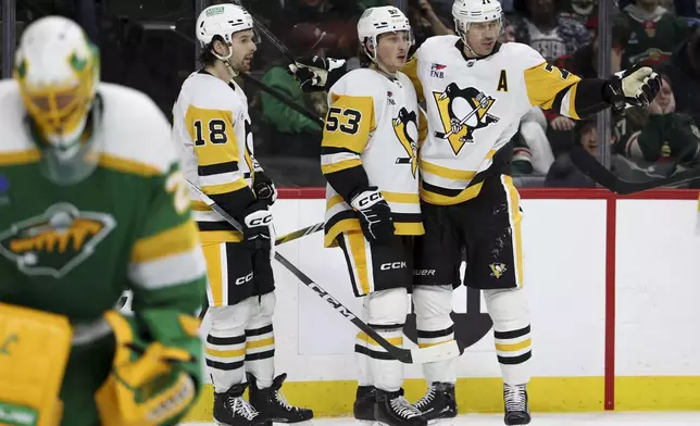 Pittsburgh Penguins center Evgeni Malkin (71) celebrates with centers Philip Tomasino (53) and Tommy Novak (18) after scoring a power play goal during the second period of an NHL hockey game against the Minnesota Wild, Sunday, March 9, 2025, in St. Paul, Minn. (AP Photo/Ellen Schmidt)