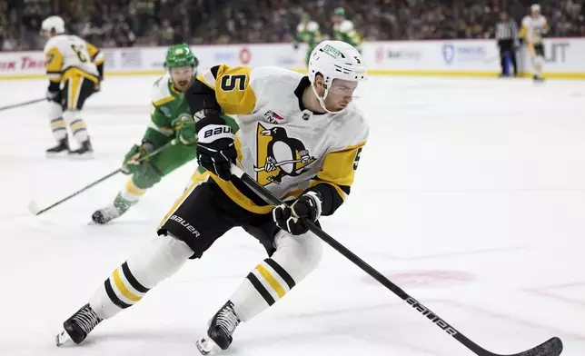 Pittsburgh Penguins defenseman Ryan Shea (5) pivots with the puck during the first period of an NHL hockey game against the Minnesota Wild, Sunday, March 9, 2025, in St. Paul, Minn. (AP Photo/Ellen Schmidt)