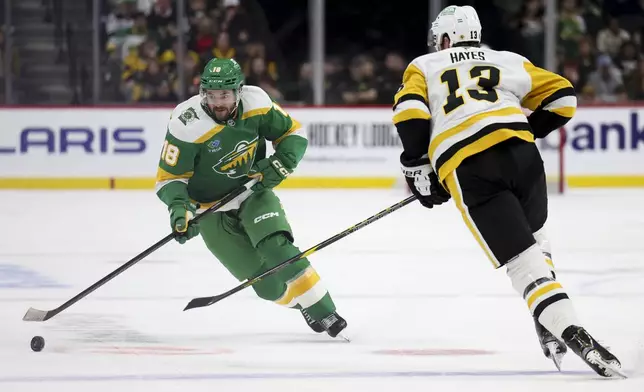 Minnesota Wild center Vinnie Hinostroza (18) skates with the puck against Pittsburgh Penguins right wing Kevin Hayes (13) during the first period of an NHL hockey game, Sunday, March 9, 2025, in St. Paul, Minn. (AP Photo/Ellen Schmidt)
