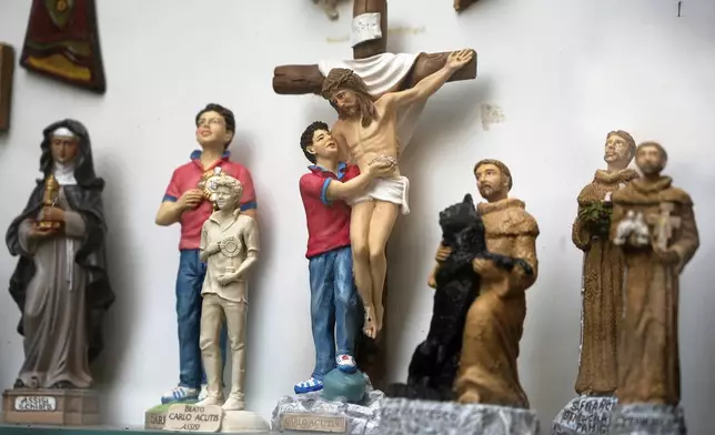 Statuettes of Carlo Acutis, an Italian boy who died in 2006 of leukemia, are displayed in a shop in Assisi, Italy, on Saturday, March 1, 2025. (AP Photo/Gregorio Borgia)