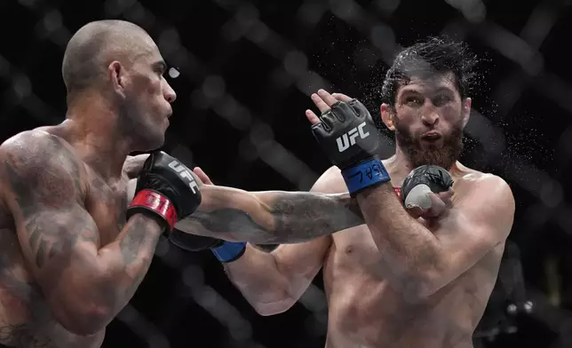 Alex Pereira hits Magomed Ankalaev during a UFC 313 mixed martial arts light heavyweight title bout Saturday, March 8, 2025, in Las Vegas. (AP Photo/John Locher)