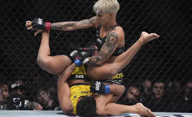 Amanda Lemos, right, fights Iasmin Lucindo during a UFC 313 mixed martial arts strawweight bout Saturday, March 8, 2025, in Las Vegas. (AP Photo/John Locher)