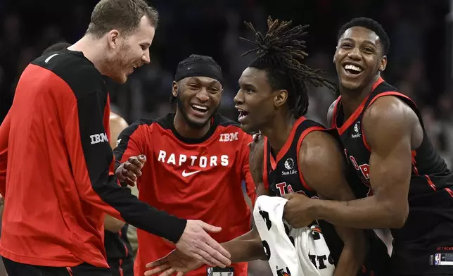 Toronto Raptors guard Ja'Kobe Walter, second from right, is congratulated by center Jakob Poeltl, left, guard Immanuel Quickley, second from left, and guard RJ Barrett, right, after his game-winning shot during the second half of an NBA basketball game against the Orlando Magic, Tuesday, March 4, 2025, in Orlando, Fla. (AP Photo/Phelan M. Ebenhack)
