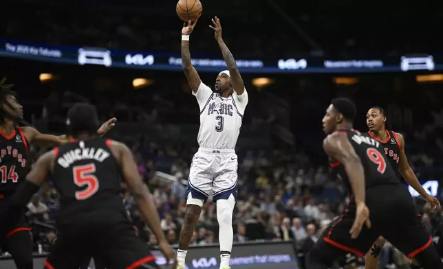 Orlando Magic guard Kentavious Caldwell-Pope (3) goes up to shoot between Toronto Raptors guard Ja'Kobe Walter (14), guard Immanuel Quickley (5), guard RJ Barrett (9) and forward Scottie Barnes, right, during the first half of an NBA basketball game, Tuesday, March 4, 2025, in Orlando, Fla. (AP Photo/Phelan M. Ebenhack)