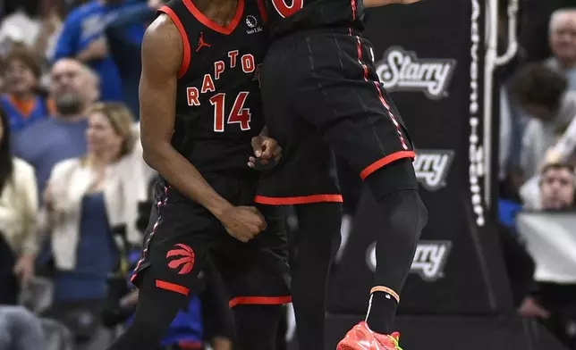 Toronto Raptors guard Ja'Kobe Walter (14) celebrates his game-winning shot with guard A.J. Lawson (0) during the second half of an NBA basketball game against the Orlando Magic, Tuesday, March 4, 2025, in Orlando, Fla. (AP Photo/Phelan M. Ebenhack)
