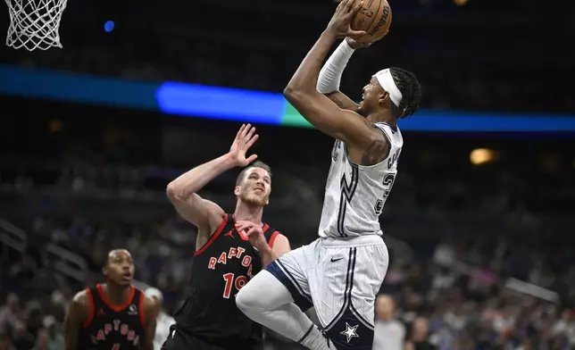 Orlando Magic center Wendell Carter Jr., right, goes up to shoot as Toronto Raptors center Jakob Poeltl (19) defends during the first half of an NBA basketball game, Tuesday, March 4, 2025, in Orlando, Fla. (AP Photo/Phelan M. Ebenhack)