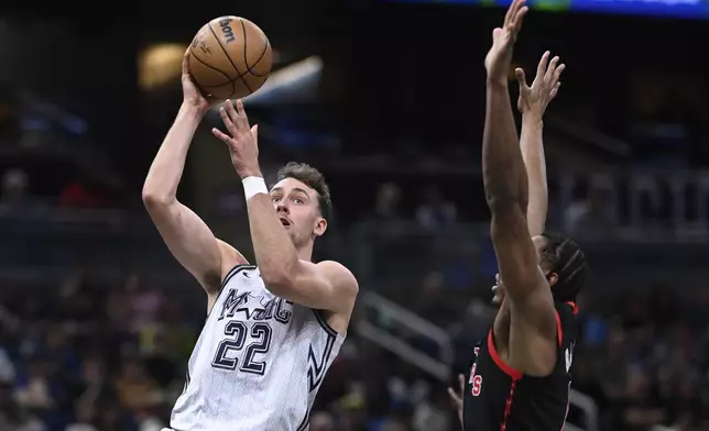 Orlando Magic forward Franz Wagner (22) goes up to shoot as Toronto Raptors forward Scottie Barnes defends during the first half of an NBA basketball game, Tuesday, March 4, 2025, in Orlando, Fla. (AP Photo/Phelan M. Ebenhack)