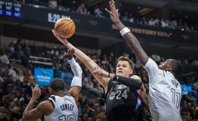 Utah Jazz center Walker Kessler (24) takes the ball to the hoop, as Minnesota Timberwolves guard Mike Conley (10) and Timberwolves center Naz Reid (11) defends during the first half of an NBA basketball game Friday, Feb. 28, 2025, in Salt Lake City. (AP Photo/Rick Egan)