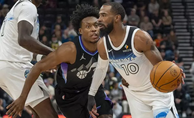 Minnesota Timberwolves guard Mike Conley (10) takes the ball inside as Utah Jazz guard Collin Sexton, left, defends during the first half of an NBA basketball game Friday, Feb. 28, 2025, in Salt Lake City. (AP Photo/Rick Egan)