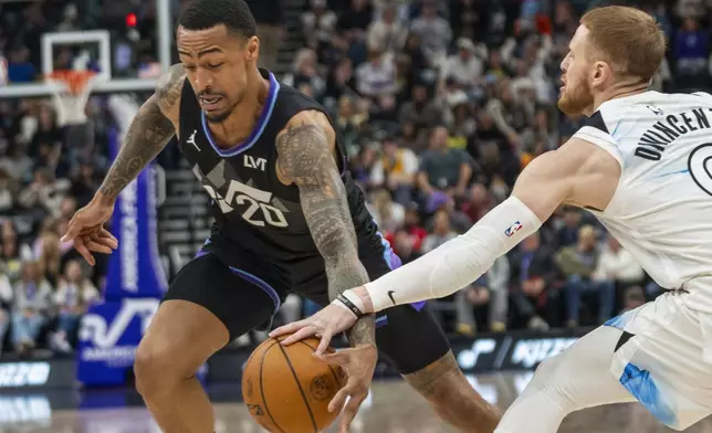 Utah Jazz forward John Collins (20) takes the ball inside as Minnesota Timberwolves guard Donte DiVincenzo, right, defends during the first half of an NBA basketball game Friday, Feb. 28, 2025, in Salt Lake City. (AP Photo/Rick Egan)
