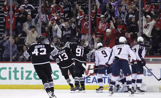 New Jersey Devils center Nico Hischier (13) reacts after scoring a goal during the first period of an NHL hockey game against the Columbus Blue Jackets, Tuesday, March 11, 2025, in Newark, N.J. (AP Photo/Adam Hunger)
