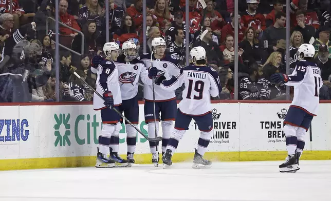 Columbus Blue Jackets right wing Kirill Marchenko, second left, is congratulated by teammates after scoring a goal during the second period of an NHL hockey game against the New Jersey Devils, Tuesday, March 11, 2025, in Newark, N.J. (AP Photo/Adam Hunger)