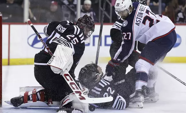 New Jersey Devils goaltender Jacob Markstrom makes a save on a shot by Columbus Blue Jackets center Zachary Aston-Reese (27) during the first period of an NHL hockey game Tuesday, March 11, 2025, in Newark, N.J. (AP Photo/Adam Hunger)