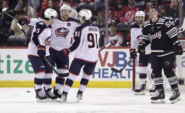 Columbus Blue Jackets right wing Mathieu Olivier is congratulated by Denton Mateychuk (5) and Kent Johnson (91) after scoring a goal during the second period of an NHL hockey game against the New Jersey Devils, Tuesday, March 11, 2025, in Newark, N.J. (AP Photo/Adam Hunger)
