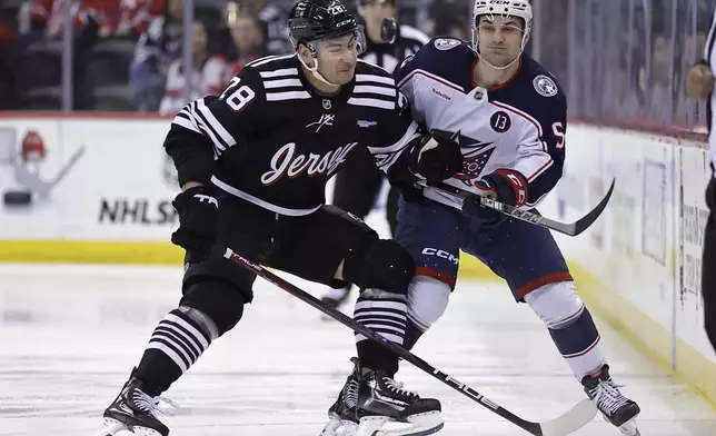 New Jersey Devils right wing Timo Meier (28) checks Columbus Blue Jackets defenseman Denton Mateychuk during the first period of an NHL hockey game Tuesday, March 11, 2025, in Newark, N.J. (AP Photo/Adam Hunger)