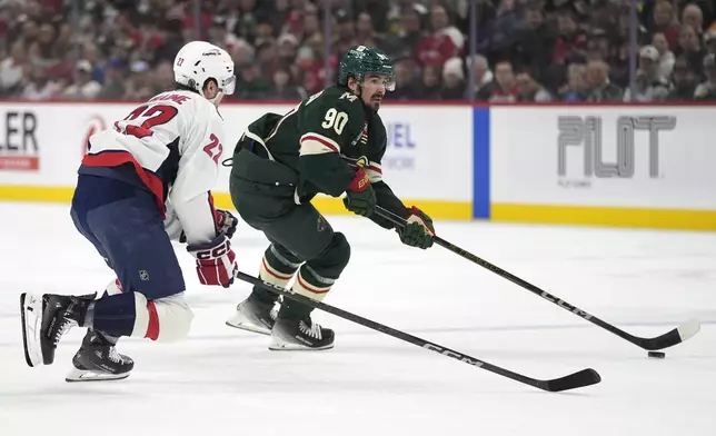 Minnesota Wild left wing Marcus Johansson (90) skates with the puck as Washington Capitals right wing Brandon Duhaime (22) follows during the first period of an NHL hockey game, Thursday, March 27, 2025, in St. Paul, Minn. (AP Photo/Abbie Parr)