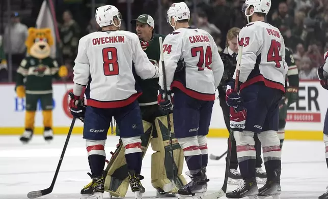 Washington Capitals left wing Alex Ovechkin (8) and Minnesota Wild goaltender Marc-Andre Fleury (29), back, talk after an NHL hockey game, Thursday, March 27, 2025, in St. Paul, Minn. (AP Photo/Abbie Parr)