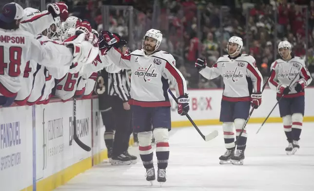 Washington Capitals defenseman Matt Roy (3) celebrates with teammates after scoring a goal during the first period of an NHL hockey game against the Minnesota Wild, Thursday, March 27, 2025, in St. Paul, Minn. (AP Photo/Abbie Parr)