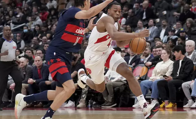 Toronto Raptors forward Scottie Barnes (4) drives past Washington Wizards forward Kyshawn George, left, during first-half NBA basketball game action in Toronto, Monday, March 10, 2025. (Nathan Denette/The Canadian Press via AP)