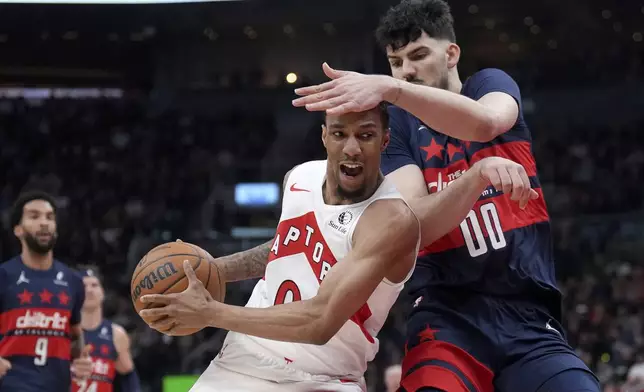 Toronto Raptors guard A.J. Lawson (0) and Washington Wizards forward Tristan Vukcevic (00) collide during first-half NBA basketball game action in Toronto, Monday, March 10, 2025. (Nathan Denette/The Canadian Press via AP)