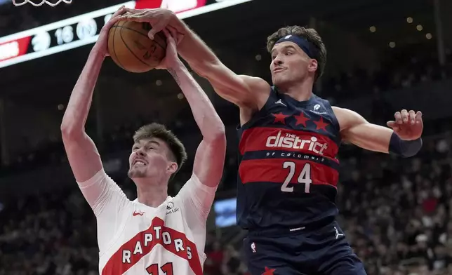 Washington Wizards forward Corey Kispert (24) rejects Toronto Raptors centre Colin Castleton (11) during first-half NBA basketball game action in Toronto, Monday, March 10, 2025. (Nathan Denette/The Canadian Press via AP)