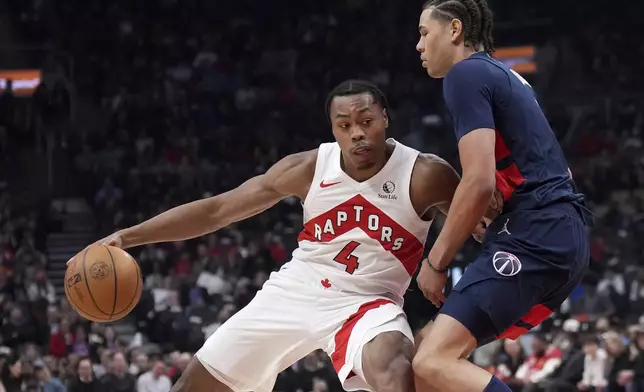 Toronto Raptors forward Scottie Barnes (4) looks to get past Washington Wizards forward Kyshawn George, right, during first-half NBA basketball game action in Toronto, Monday, March 10, 2025. (Nathan Denette/The Canadian Press via AP)