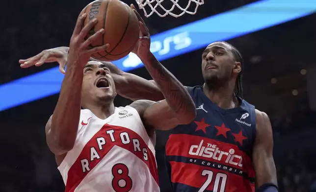 Toronto Raptors guard Jared Rhoden (8) drives to the net while under pressure from Washington Wizards forward Alex Sarr (20) during first-half NBA basketball game action in Toronto, Monday, March 10, 2025. (Nathan Denette/The Canadian Press via AP)