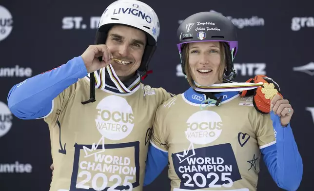 Gold medalists Elisa Caffont of Italy and Maurizio Bormolini of Italy pose on the podium at the Snowboard Alpine Parallel-Slalom competition at the FIS Snowboard, Freestyle and Freeski World Championships, Sunday, March 23, 2025, in St. Moritz, Switzerland. (Gian Ehrenzeller/Keystone via AP)