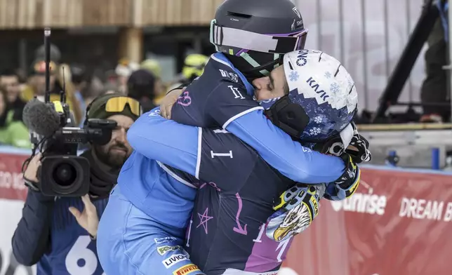 Gold medalists Maurizio Bormolini and Elisa Caffont of Itals celebrate in the finish area at the Snowboard Alpine Parallel-Slalom competition at the FIS Snowboard, Freestyle and Freeski World Championships, Sunday, March 23, 2025, in St. Moritz, Switzerland. (Gian Ehrenzeller/Keystone via AP)