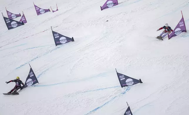 Dario Caviezel of Switzerland, right, and Andreas Prommegger of Austria, in action during the small final at the Snowboard Alpine Parallel-Slalom competition at the FIS Snowboard, Freestyle and Freeski World Championships, Sunday, March 23, 2025, in St. Moritz, Switzerland. (Gian Ehrenzeller/Keystone via AP)