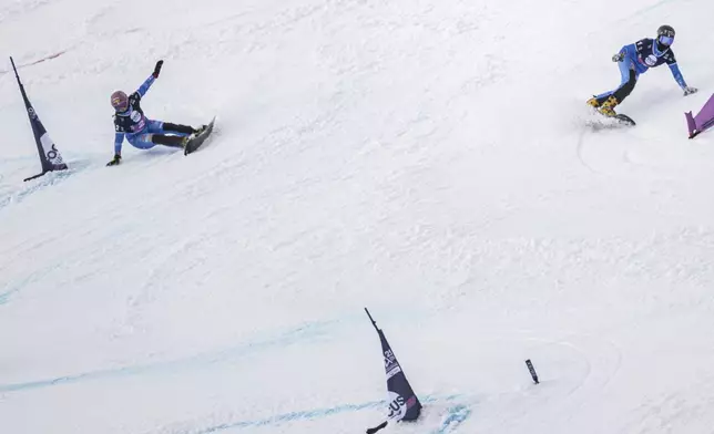Elisa Caffont of Italy, right, and Jasmin Coratti of Italy in action during the big final at the Snowboard Alpine Parallel-Slalom competition at the FIS Snowboard, Freestyle and Freeski World Championships, Sunday, March 23, 2025, in St. Moritz, Switzerland. (Gian Ehrenzeller/Keystone via AP)