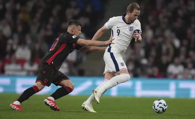 England's Harry Kane challenges for the ball with Albania's Ylber Ramadani during a World Cup qualifying soccer match between England and Albania at Wembley stadium in London, Friday, March 21, 2025. (AP Photo/Alastair Grant)
