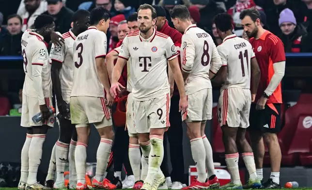 Munich's Harry Kane, front, does not attend a short team meeting during the Champions League round of 16 first leg soccer match between FC Bayern Munich and Bayer 04 Leverkusen in Munich, Germany, Wednesday, March 5, 2025. (Peter Kneffel/dpa via AP)