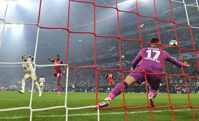 Munich's Harry Kane, left, scores the opening goal during the Champions League round of 16 first leg soccer match between FC Bayern Munich and Bayer 04 Leverkusen in Munich, Germany, Wednesday, March 5, 2025. (Peter Kneffel/dpa via AP)