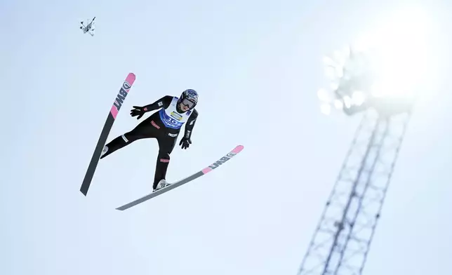 =Marius Lindvik, of Norway, soars through the air during his first round jump of the ski jumping men's team large hill competition at the Nordic World Ski Championships in Trondheim, Norway, Thursday, March 6, 2025. (AP Photo/Matthias Schrader)