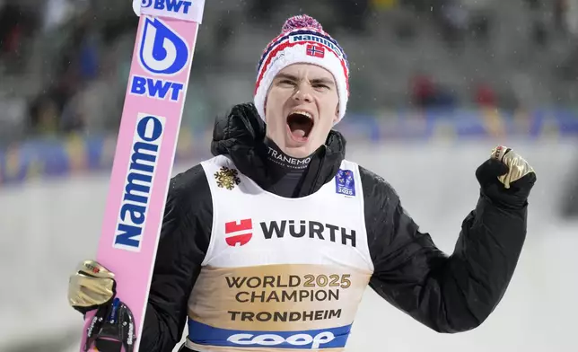 Marius Lindvik, of Norway, celebrates after winning the gold medal in the ski jumping men's normal hill HS102 event at the Nordic World Ski Championships in Trondheim, Norway, Sunday, March 2, 2025. (AP Photo/Matthias Schrader)