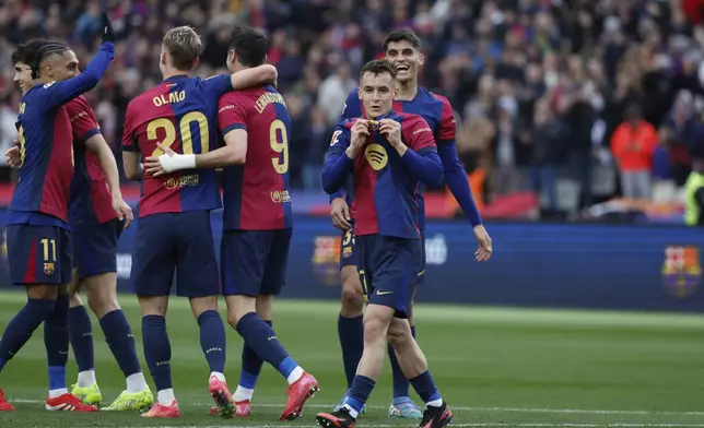 Barcelona's Marc Casado, front, celebrates scoring his side's 2nd goal during the Spanish La Liga soccer match between Barcelona and Real Sociedad at the Lluis Companys Olympic Stadium in Barcelona, Spain, Sunday, March 2, 2025. (AP Photo/Joan Monfort)