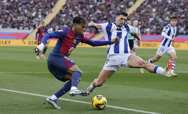 Barcelona's Lamine Yamal, left, dribbles the ball challenged by Real Sociedad's Javi Lopez during the Spanish La Liga soccer match between Barcelona and Real Sociedad at the Lluis Companys Olympic Stadium in Barcelona, Spain, Sunday, March 2, 2025. (AP Photo/Joan Monfort)