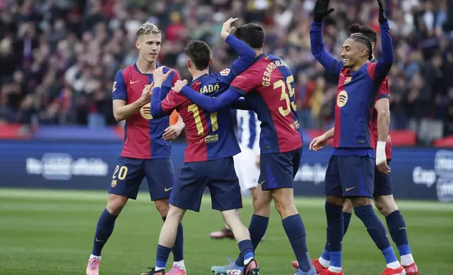 Barcelona's Marc Casado, second from left, is congratulated after scoring his side's 2nd goal during the Spanish La Liga soccer match between Barcelona and Real Sociedad at the Lluis Companys Olympic Stadium in Barcelona, Spain, Sunday, March 2, 2025. (AP Photo/Joan Monfort)