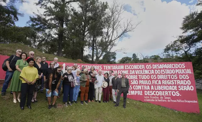 Brazilian Minister of Human Rights Macae Evaristo, seventh from right in the front row, poses for a photo with relatives of victims of the country's military dictatorship (1964-1985) during a government ceremony to apologize to families, at the Dom Bosco cemetery in Sao Paulo, Monday, March 24, 2025. (AP Photo/Andre Penner)