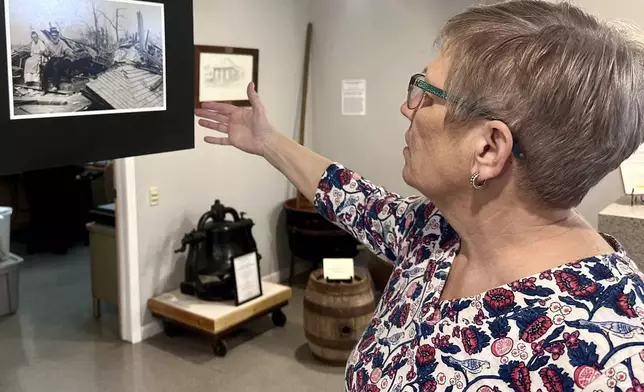 Jackson County Historical Society President Laura Cates Duncan describes a photo on display at the society's office of an elderly couple sitting on the ruins of their home after the March 18, 1925 Tri-State Tornado on March 11, 2025 in Murphysboro, Ill. (AP Photo/John O'Connor)