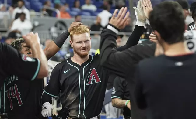 Arizona Diamondbacks' Pavin Smith, center, is congratulated after hitting a solo home run during the sixth inning of a baseball game against the Miami Marlins, Wednesday, April 16, 2025, in Miami. (AP Photo/Lynne Sladky)