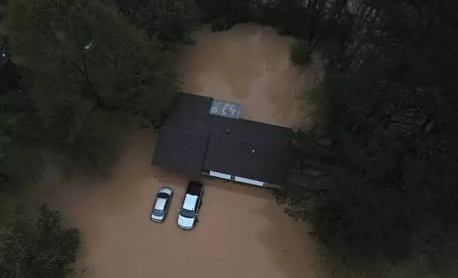 Floodwaters inundate homes and vehicles in Shannon Hills, Ark., Saturday, April 5, 2025, as a second day of storms brought widespread flooding to the region. (Colin Murphey/Arkansas Democrat-Gazette via AP)
