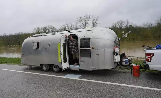 CORRECTS TO MICHAEL NOT MICHALE Michael Scott Memering looks out of his trailer after evacuating the Licking River RV Campground that was flooded by the rising waters of the Licking River, seen behind, Sunday, April 6, 2025, in Falmouth, Ky. (AP Photo/Carolyn Kaster)