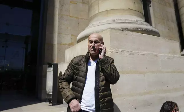 Yunice Abbas, one of the men accused in the 2016 armed robbery of Kim Kardashian, gives a phone call outside the palace of justice Monday, April 28, 2025 in Paris. (AP Photo/Aurelien Morissard)